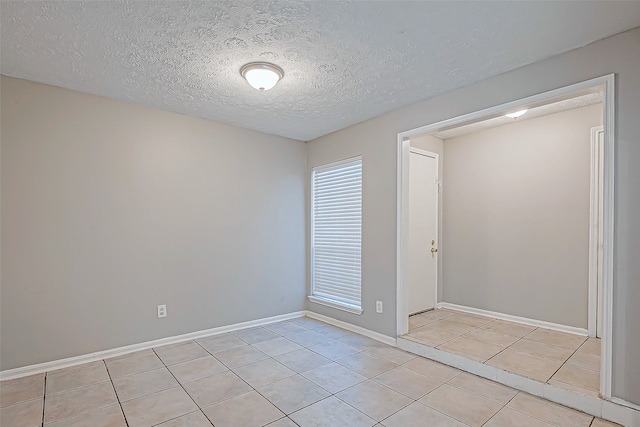 tiled spare room featuring a textured ceiling