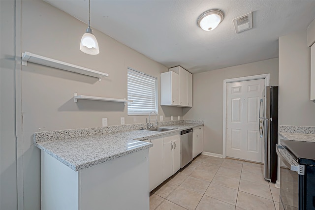 kitchen featuring appliances with stainless steel finishes, decorative light fixtures, white cabinetry, and sink