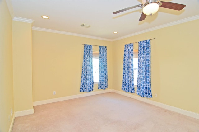 empty room featuring crown molding, light colored carpet, and ceiling fan