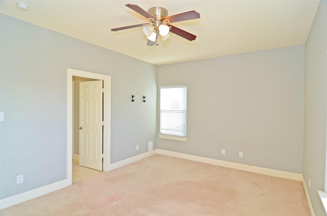 empty room featuring light colored carpet and ceiling fan