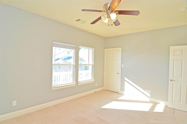 spare room with ceiling fan and light carpet