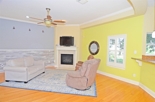 living room with hardwood / wood-style flooring, ornamental molding, and ceiling fan