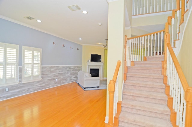 staircase featuring ornamental molding, hardwood / wood-style floors, and ceiling fan