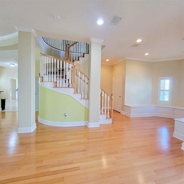 interior space with ornamental molding and light hardwood / wood-style flooring