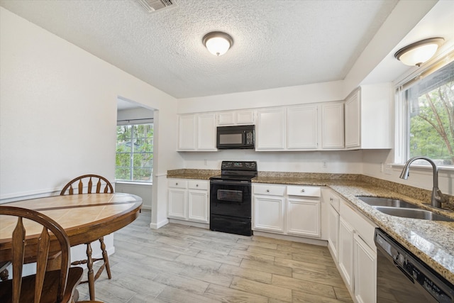 kitchen with sink, white cabinetry, and black appliances