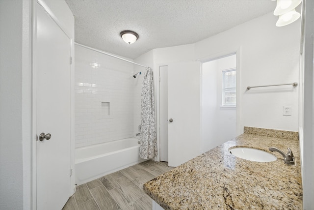 bathroom with vanity, wood-type flooring, a textured ceiling, and shower / tub combo with curtain