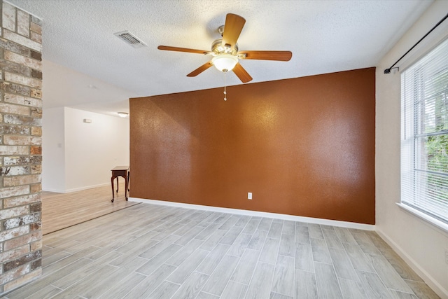 unfurnished room with ceiling fan, light hardwood / wood-style floors, and a textured ceiling