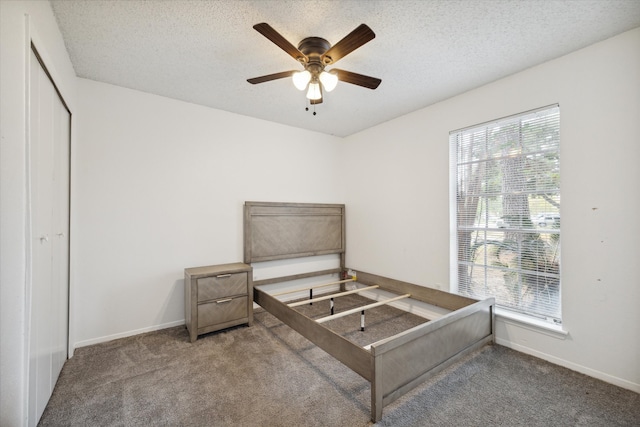 bedroom featuring carpet flooring, ceiling fan, a textured ceiling, and multiple windows