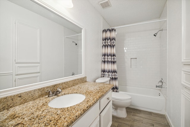 full bathroom with vanity, toilet, a textured ceiling, and shower / tub combo with curtain