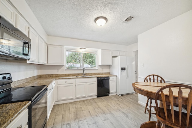 kitchen with light wood-type flooring, sink, white cabinetry, and black appliances