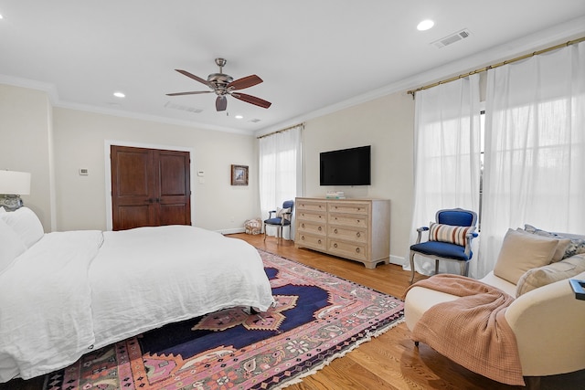 bedroom featuring ceiling fan, light wood-type flooring, and crown molding