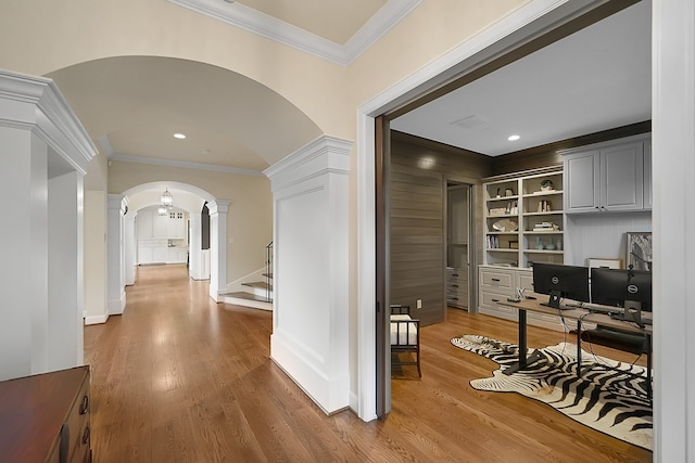 hallway featuring hardwood / wood-style floors, built in shelves, and crown molding