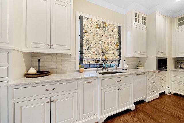 kitchen featuring white cabinetry, sink, dark wood-type flooring, light stone counters, and backsplash