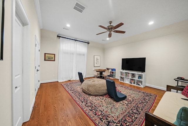 living room featuring wood-type flooring and ceiling fan