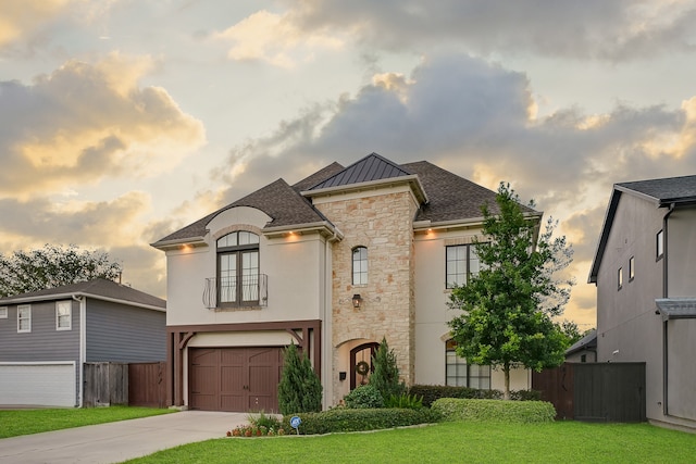 french provincial home with a yard, a balcony, and a garage