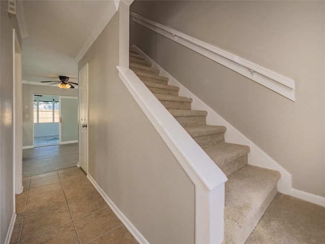 stairs featuring tile patterned floors, baseboards, ornamental molding, and ceiling fan