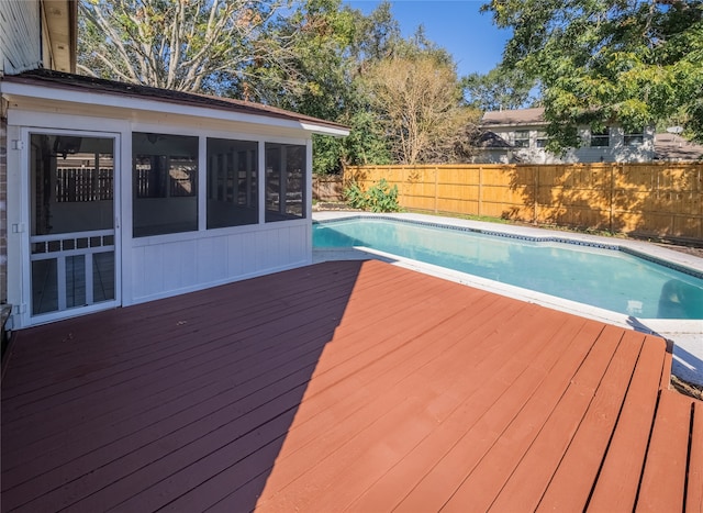 view of pool with a deck and a sunroom