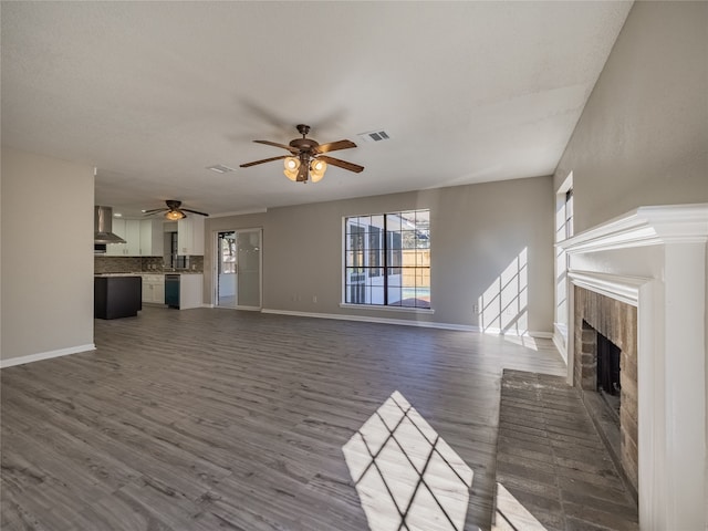 unfurnished living room featuring ceiling fan and dark wood-type flooring