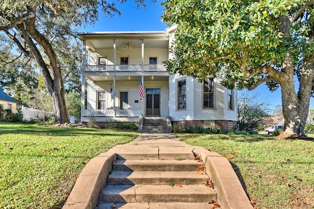 view of front facade with covered porch, a balcony, and a front lawn