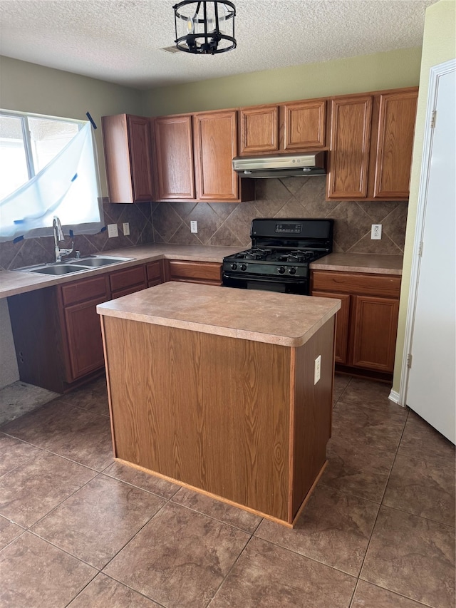 kitchen featuring dark tile patterned flooring, a center island, sink, and black range with gas cooktop