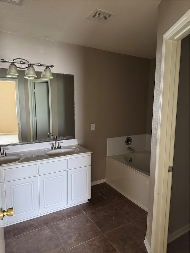 bathroom with tile patterned flooring, vanity, and a tub to relax in