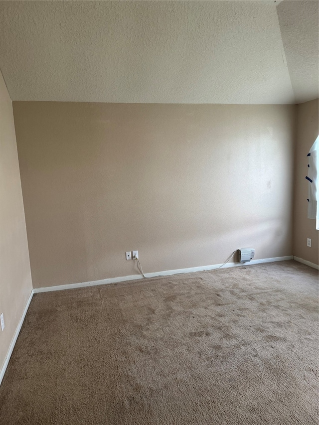 carpeted empty room featuring a textured ceiling