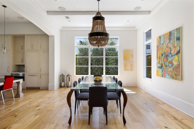 dining area with beam ceiling and light hardwood / wood-style flooring