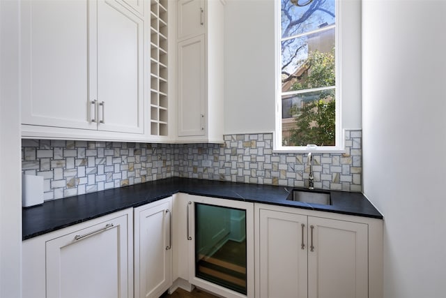 kitchen featuring white cabinets, decorative backsplash, wine cooler, and sink