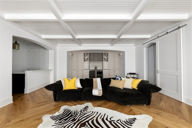 living room featuring beamed ceiling, a barn door, and coffered ceiling