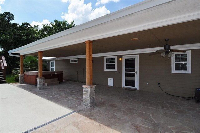 view of patio with ceiling fan and a hot tub