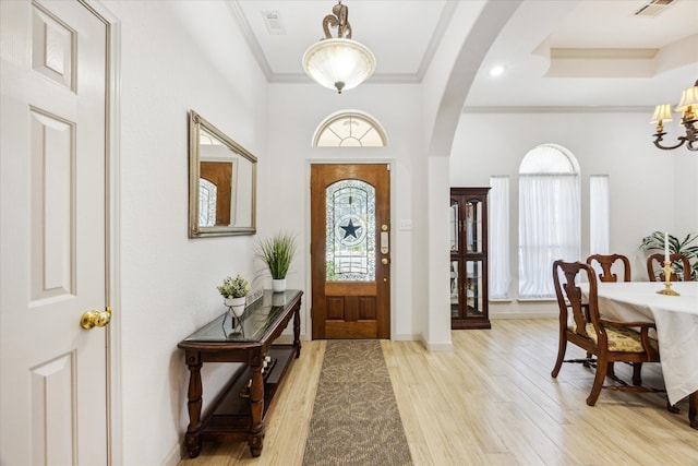 foyer entrance featuring ornamental molding and light wood-type flooring