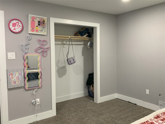 unfurnished bedroom with dark colored carpet and a closet