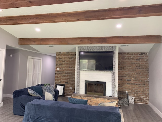 living room with a fireplace, beamed ceiling, and wood-type flooring