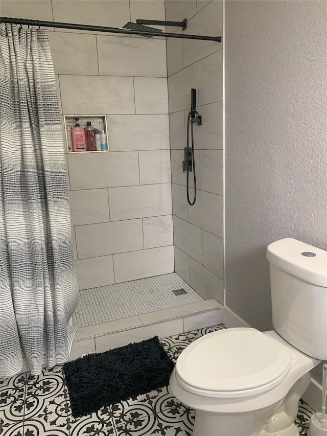 bathroom with tile patterned floors, toilet, and a shower with shower curtain