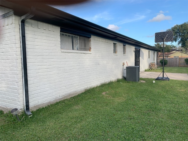 view of property exterior featuring a lawn and central AC