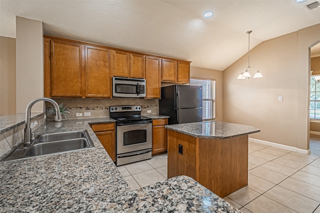 kitchen with plenty of natural light, sink, appliances with stainless steel finishes, and vaulted ceiling