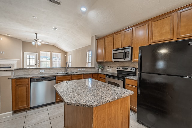 kitchen with ceiling fan, sink, a center island, lofted ceiling, and appliances with stainless steel finishes