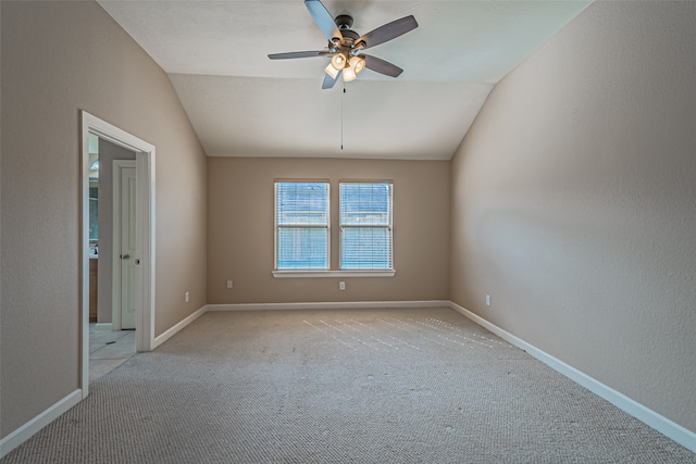 unfurnished room with light colored carpet, vaulted ceiling, and ceiling fan