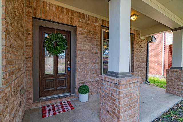 view of exterior entry featuring covered porch