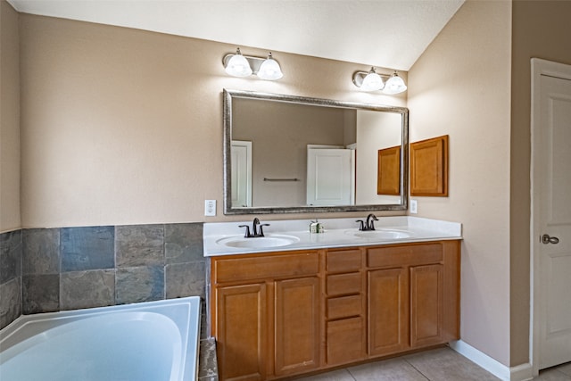 bathroom with tile patterned floors, vanity, vaulted ceiling, and a bathing tub