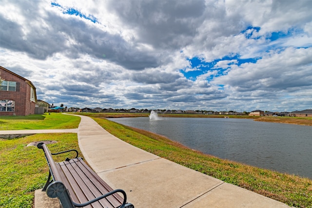 view of home's community featuring a water view and a yard