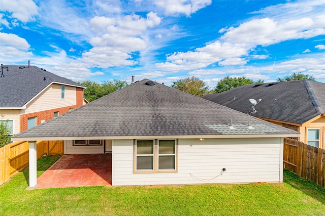 rear view of house with a yard and a patio