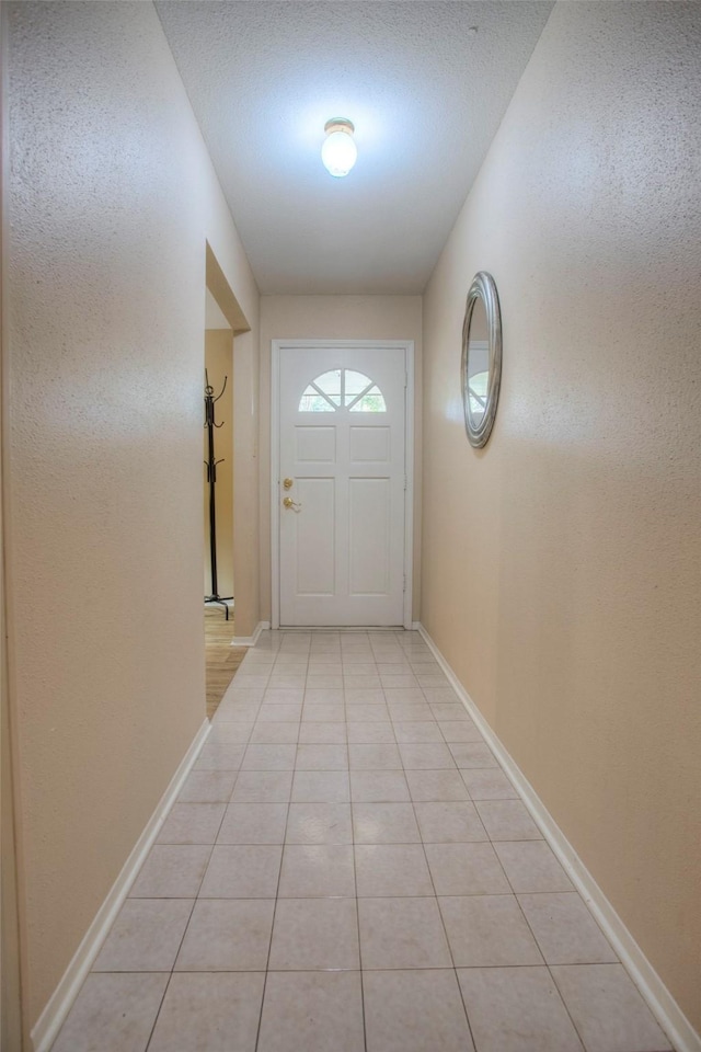 entryway featuring light tile patterned floors and baseboards