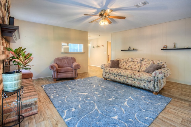 living room with wood-type flooring, ceiling fan, and wooden walls