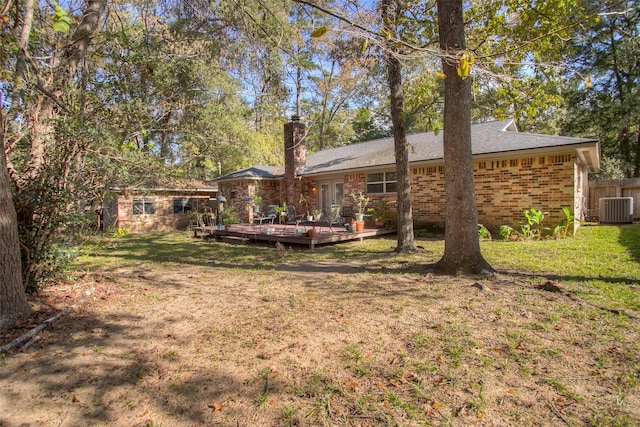 back of house featuring a yard, central AC, brick siding, and a deck