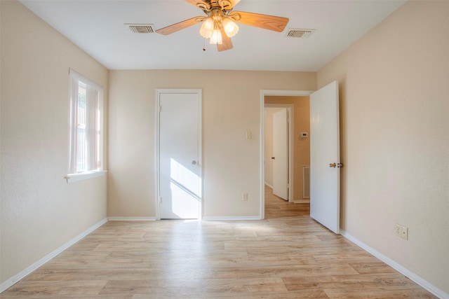 unfurnished bedroom featuring baseboards, a ceiling fan, visible vents, and light wood-style floors