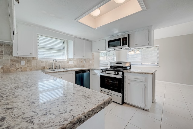 kitchen with white cabinetry, sink, tasteful backsplash, kitchen peninsula, and appliances with stainless steel finishes