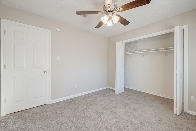 unfurnished bedroom featuring ceiling fan, light colored carpet, a textured ceiling, and a closet