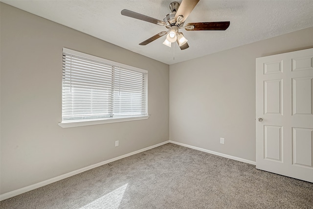 carpeted empty room featuring a textured ceiling and ceiling fan