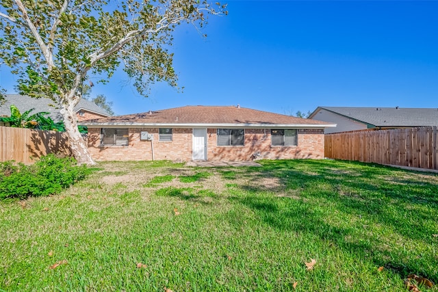 rear view of property featuring a yard